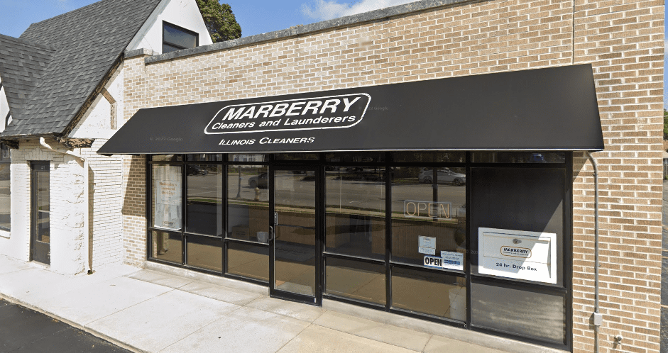 The exterior of Marberry Cleaners and Launderers with a black awning, glass storefront, and a visible “open” sign.